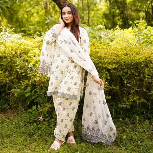 Woman in a traditional outfit standing in a green, natural setting