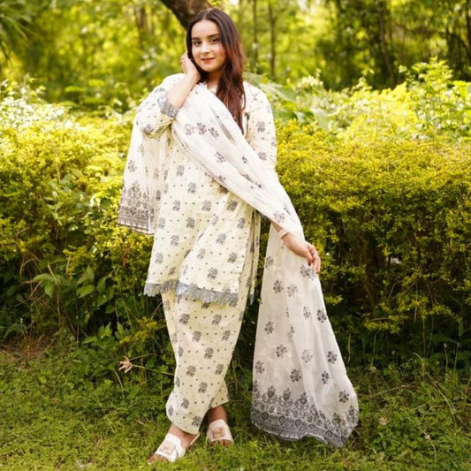 Woman in a traditional outfit standing in a green, natural setting